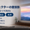 白い壁に直接映しているプロジェクターと判断基準を示したバナー