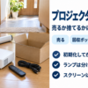 床に並べたプロジェクターとリモコン、段ボール箱、スクリーンのケース