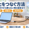 ノートパソコンとプロジェクターをケーブルとアダプタでつないだ机の上